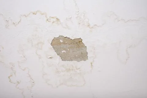 Rain water leaks on the ceiling because of damaged roof causing decay, peeling Stock Photos