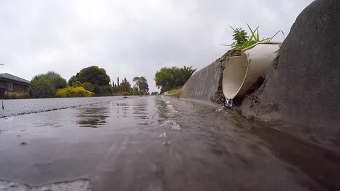 Rain water running into a drain Stock Footage 77495107