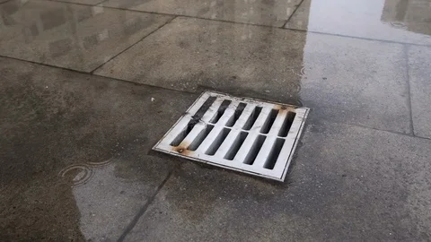 Rain water runs down drain during a heavy rain storm. Slow motion. Видео 118993462