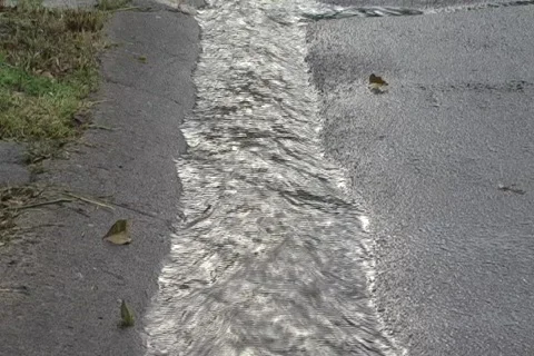 Rain water rushing in gutter  after storm  2 Stock Footage 821912
