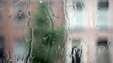 Rain on window glass with blurry background of houses and tree Stock Footage 109594695