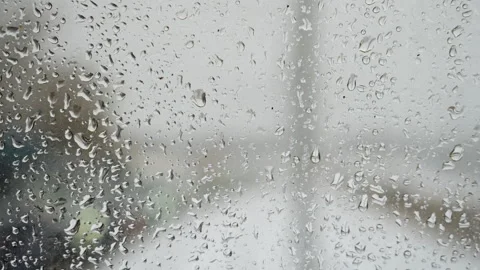 Rain on windshield reveals blurred road, distant headlights, reflective asphalt Stock Footage 345167632