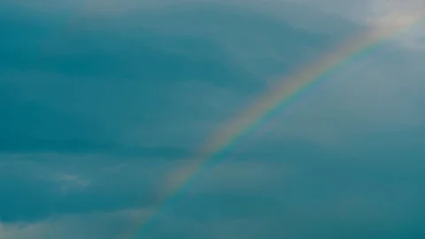 Rainbow after summer rain in cloudy blue sky. Stock Footage 111277199