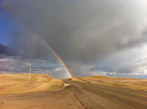 Rainbow ahead on highway Stock Photos