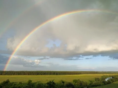 Rainbow and clouds over fields and river, smart Stock Photos