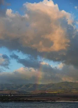 Rainbow and clouds over the water Stock Photos