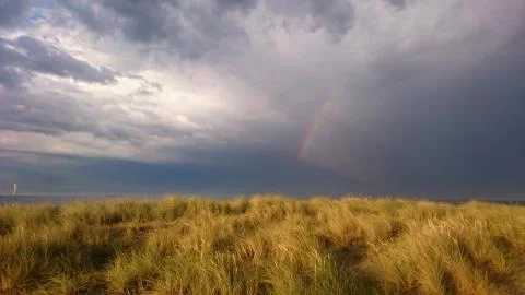 Rainbow and dramatic sky at the beach in Copenhagen - Amager Stock Photos
