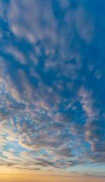 Rainbow and fluffy clouds at sunset after the rain. Stock Photos