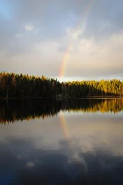 Rainbow and its reflection Stock Photos
