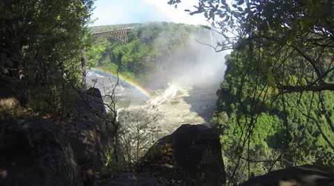 Rainbow and low clouds by Victoria Falls with Bridge Stock Footage 22883683
