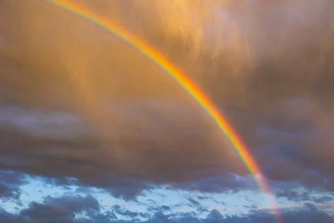 Rainbow and rain clouds at sunset Foto stock