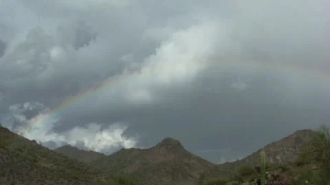 Rainbow and storm clouds drifting over Arizona mountain Stockbeeldmateriaal 326369702
