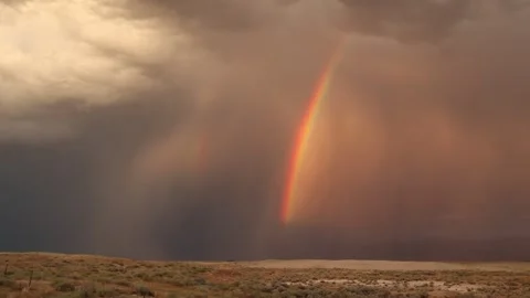 Rainbow and Storm Clouds Over Sand Dunes in Nevada Desert with Shallow DOF Stock Footage 245965946
