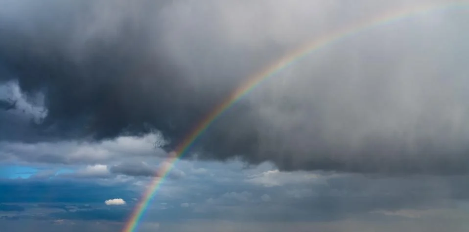 Rainbow and storm clouds at sunrise Foto stock