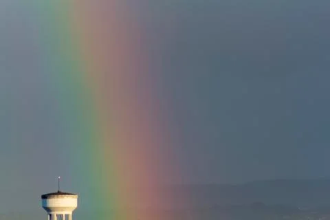 Rainbow and water tower Stock Photos