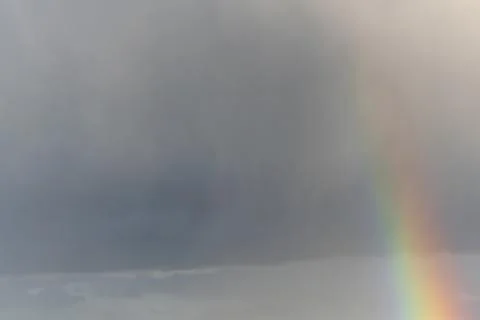 Rainbow appearing in rainy clouds in spring. Bas Rhin, Alsace, France, Europe Stock Photos