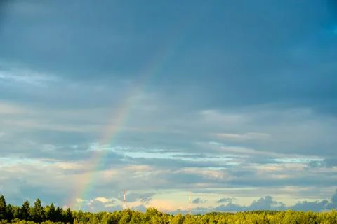 Rainbow Arc Above Forest Trees and Telecommunication Towers Foto stock