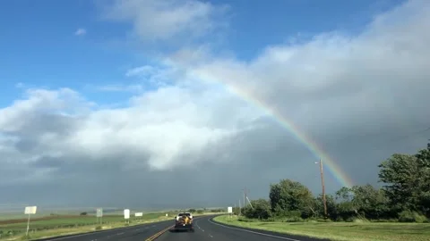 Rainbow arches over a highway Stock Footage 134306638