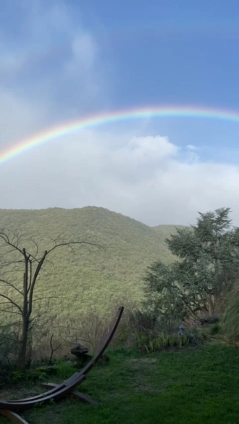 Rainbow arching over rural mountain landscape Stock Footage 340640071
