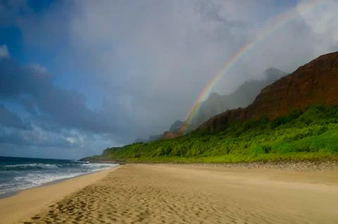 A rainbow arcs down from the mountains to the beach on the Kalalau trail, Stock Photos