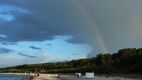 Rainbow arcs gracefully across the sky, contrasting with dark clouds. This Vidéo 282799999