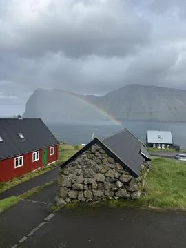 Rainbow arcs over a dramatic landscape in Faroe Islands Stock Photos