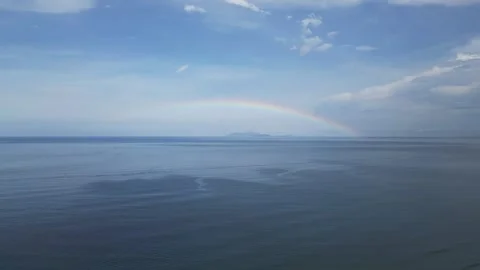 Rainbow around the distant island in the ocean Stock Footage 245354333