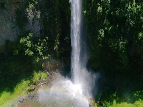 Rainbow Around Huge Waterfall Spray in Pool Aerial Rising Shot Stock Footage 79171339