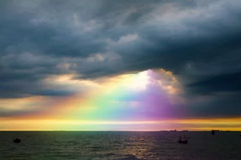Rainbow back dark cloud on sea. concept god bless, wish Stockfoto's