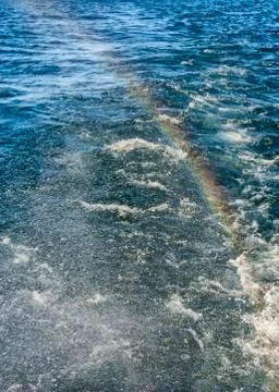 Rainbow on a background of waves and spray Stock Photos