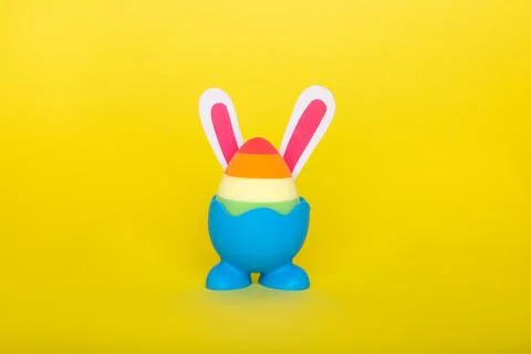 Rainbow beauty blender easter egg with bunny ears on blue stand with legs. Foto stock