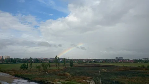 Rainbow on the blue sky with the moving clouds Stock Footage 97695884