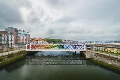 Rainbow bridge spanning river in urban landscape 库存照片
