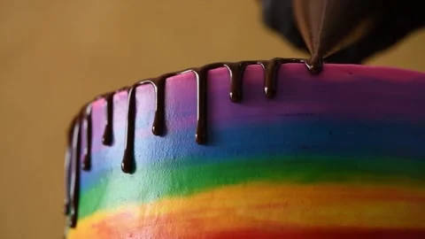 The rainbow cake is poured with chocolate icing. The symbolism of the LGBT Stock Footage 148391649