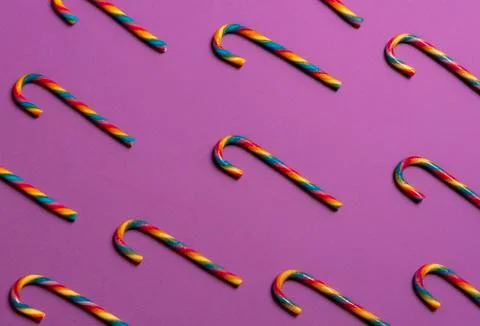 Rainbow candy canes on a purple background Stock Photos