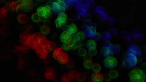 Rainbow circular bokeh lights changing size and drifting on a dark abstract.. Stock Footage 340034545