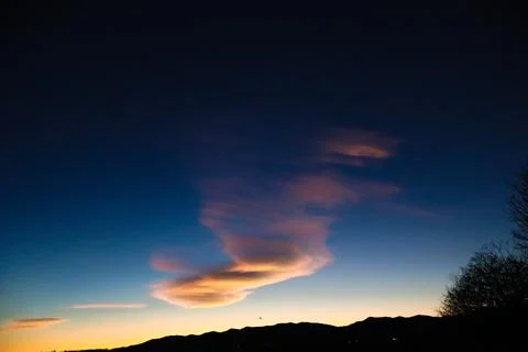 Rainbow clouds in a gold twilight. Stock Photos