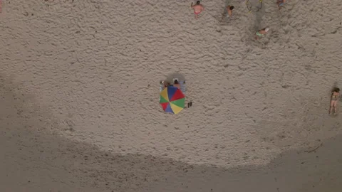 Rainbow Colored Beach Umbrella Couple Rising Aerial Stock Footage 147472924
