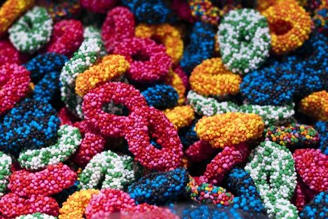 Rainbow colored crater loop shaped gummy candies forming a sweet texture. 스톡 사진