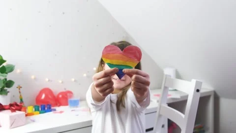 Rainbow colored heart in the hands of a cute caucasian girl Stock Footage 146165074