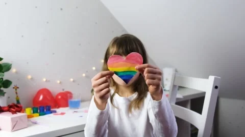 Rainbow colored heart in the hands of a cute caucasian girl.Free love, lgbt Stock Footage 146165229