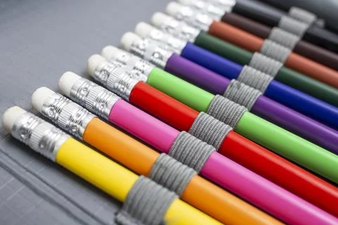 Rainbow colored pencil crayons with eraser, arranged in a pencil box, back .. Stock Photos