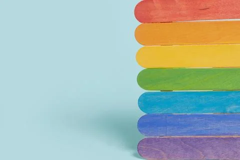 Rainbow-colored plaques on a blue background. Copy space Stock Photos