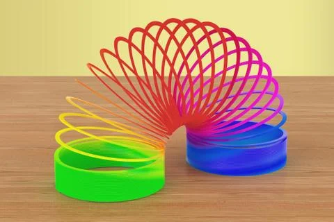 Rainbow colored plastic, slinky toy on the wooden table. 3D rendering Stock Illustration