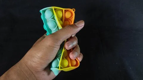 A rainbow-colored pop it toy Stock Photos