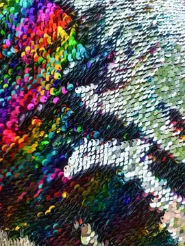 Rainbow colored sequins forming diagonal stripes creating vibrant surface Stock Photos