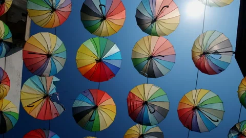 Rainbow colored umbrellas dangle over pink street in Cankiri,Turkey Stock Footage 234098740