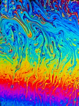 Rainbow colors created by soap, bubble, or oil makes a great abstract backgro Stock Photos