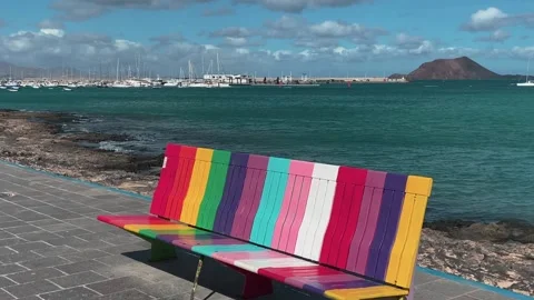 Rainbow coloured bench on Corralejo seafront Stock Footage 221427125