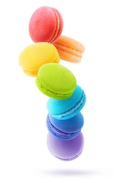 Rainbow coloured macaroons levitation. Vertical shot isolated on white back.. Stock Photos